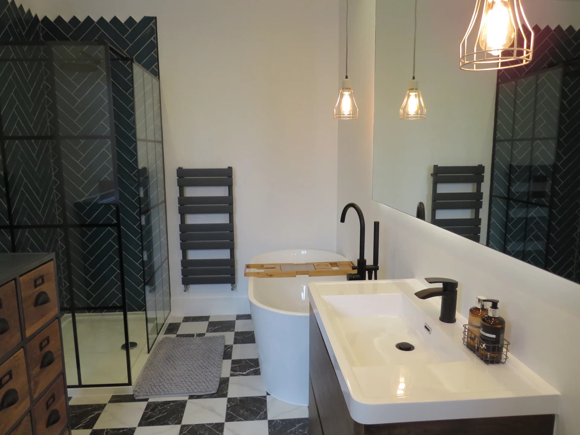 Freestanding bath, timber vanity and dark tiled shower