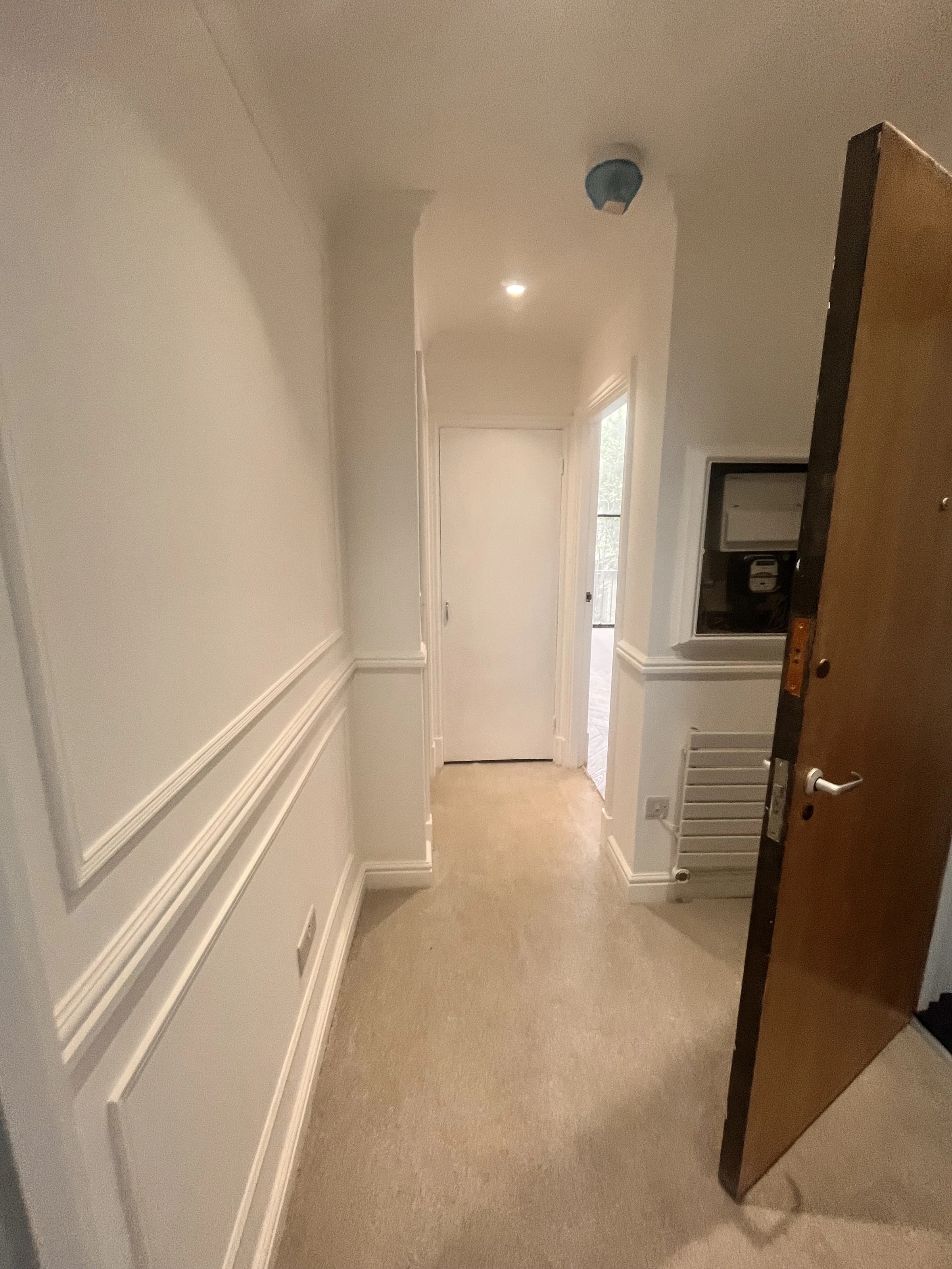 Renovated hallway with wall panelling and recessed lighting