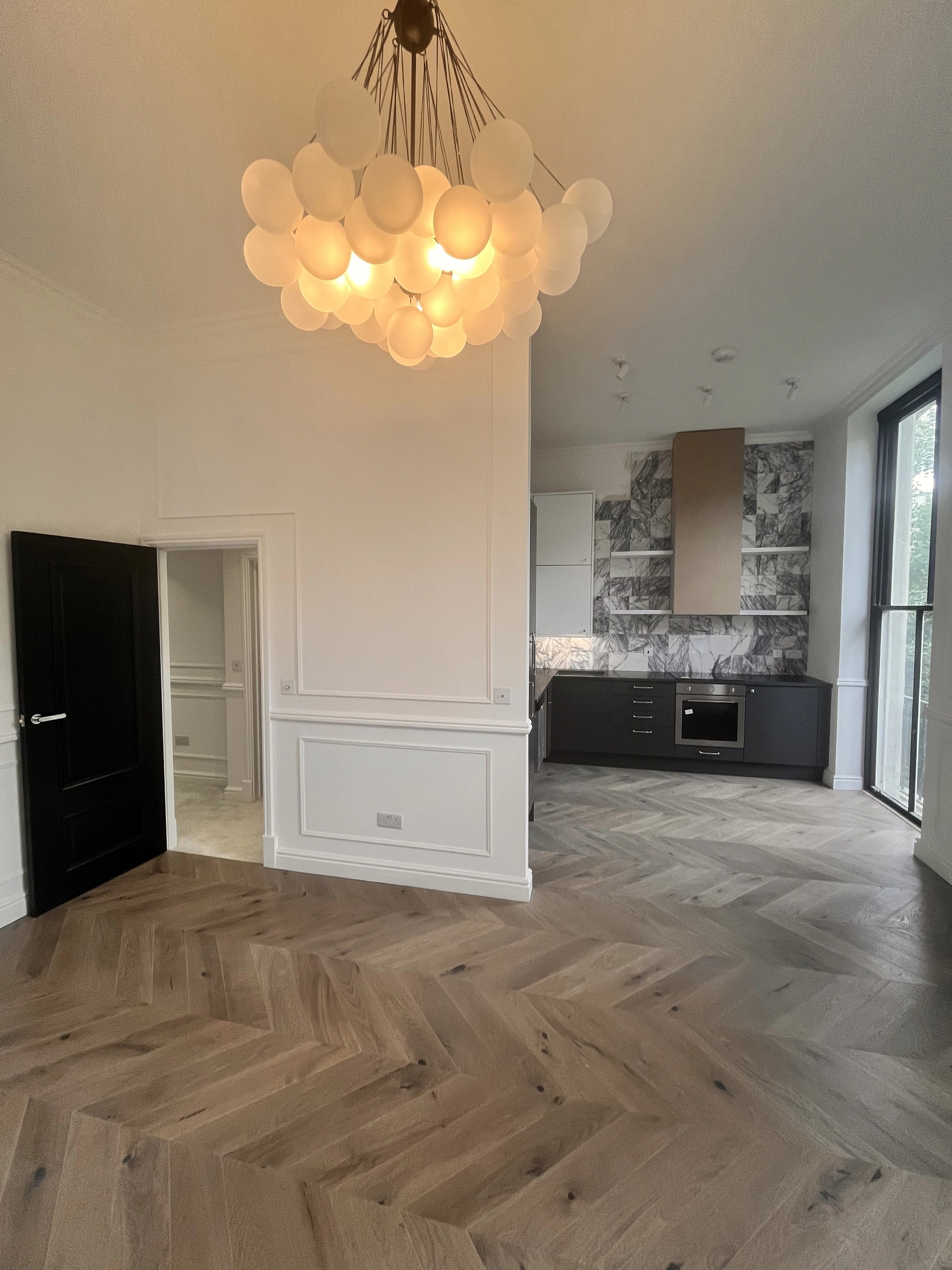 Renovated W2 flat with wall panelling, herringbone flooring and a kitchen