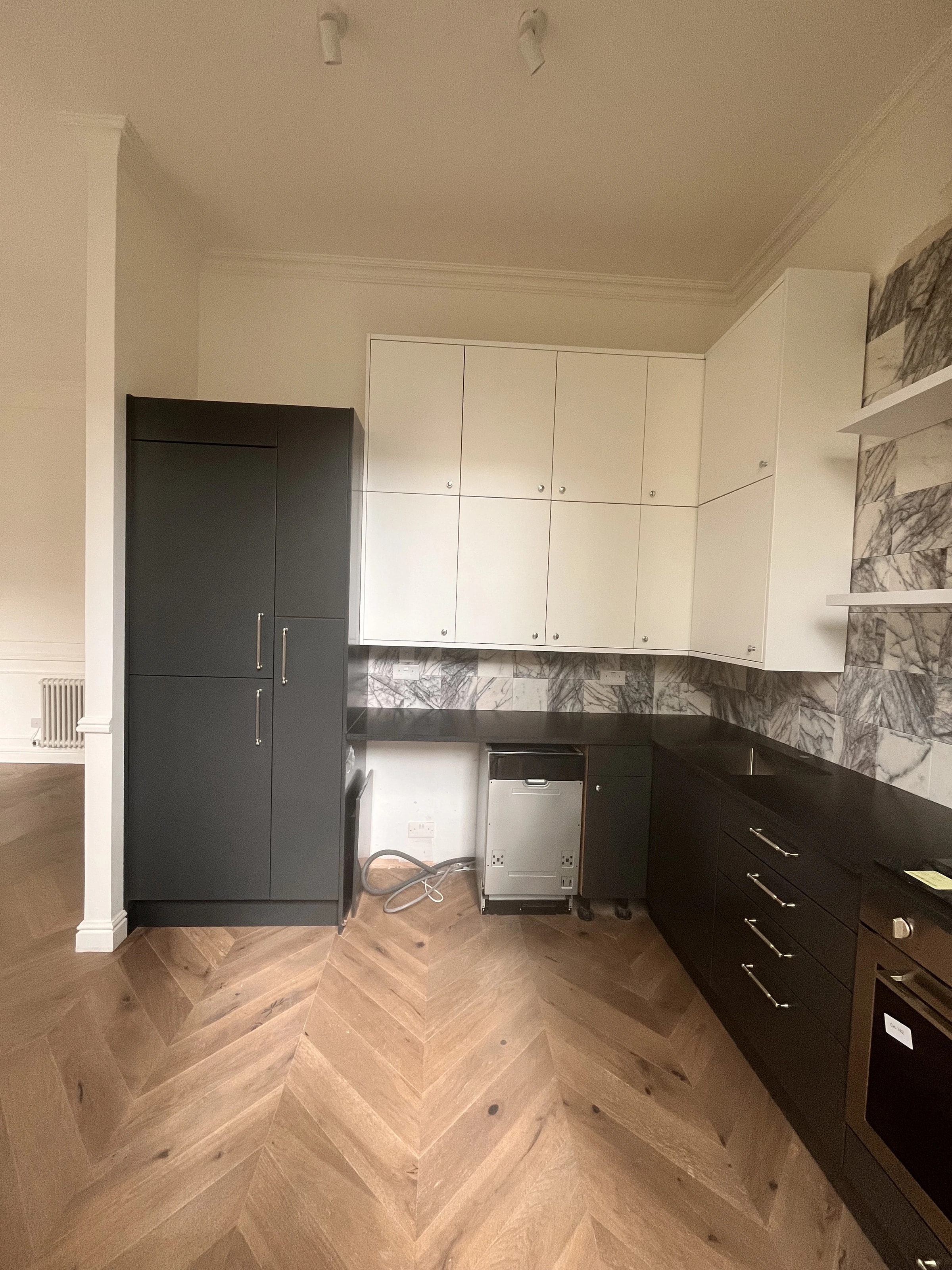 Kitchen storage and appliances with pale upper cabinetry