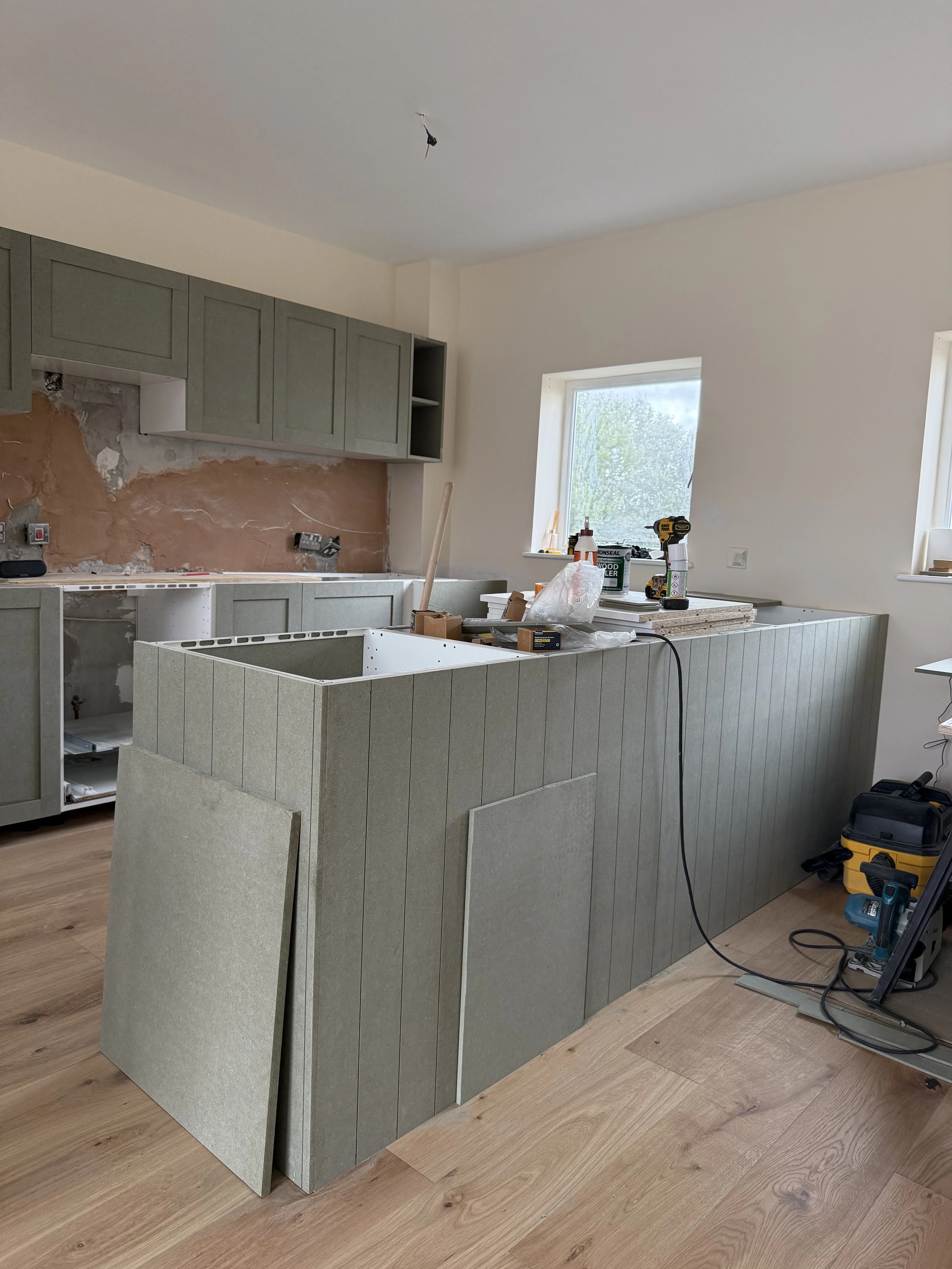 Kitchen cabinetry and island during construction before the final blue finish