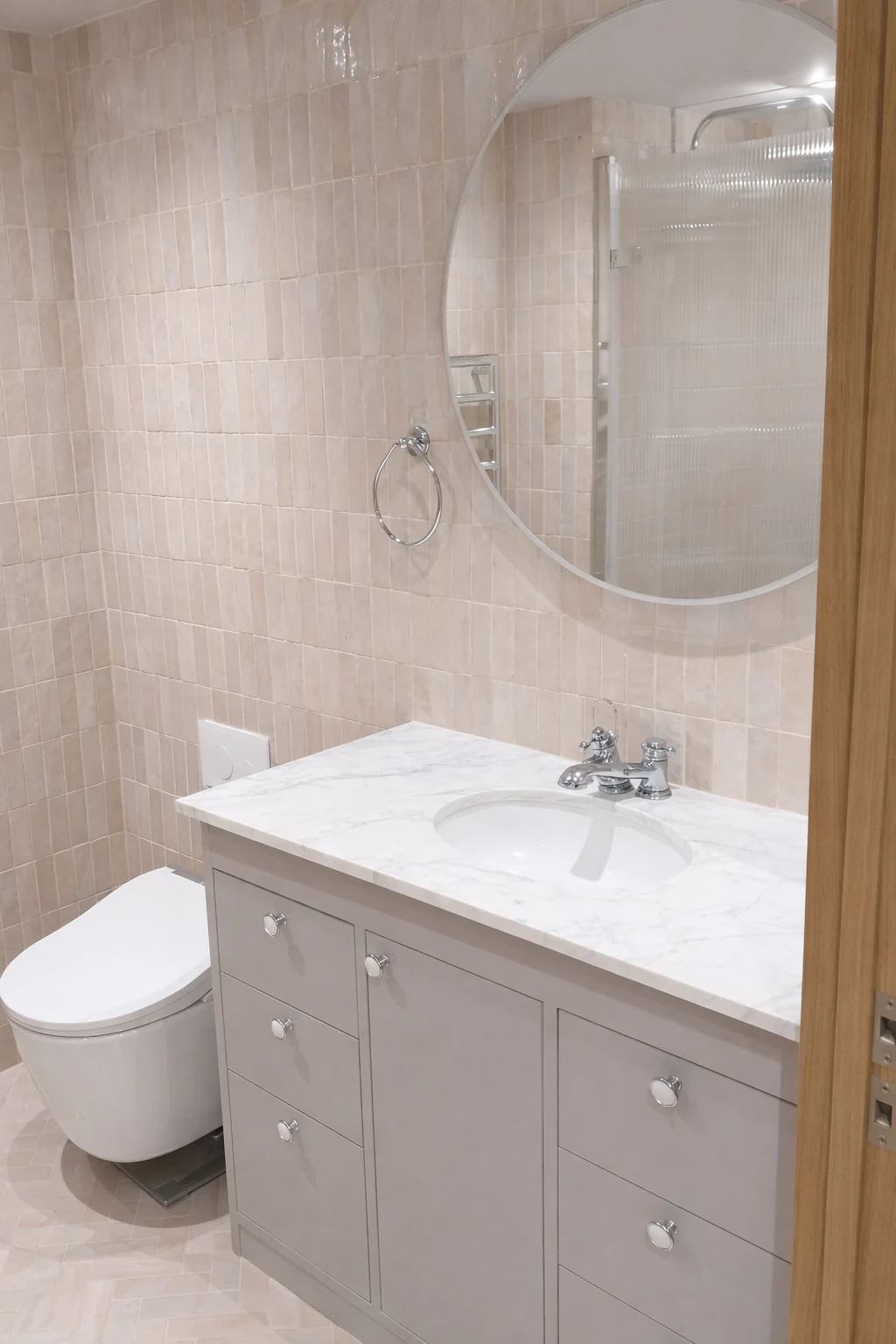 Bathroom vanity and mirror against pale wall tiles