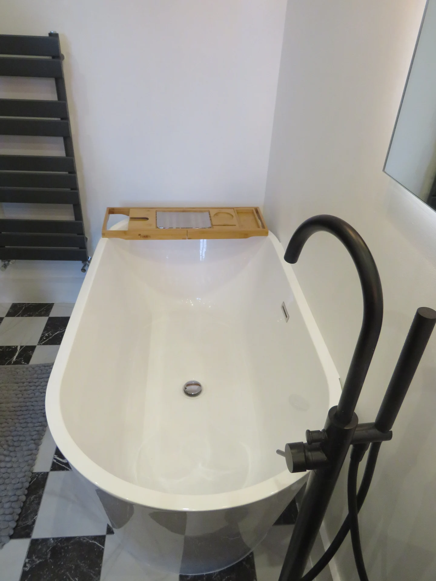 Freestanding bath with floor-mounted tap